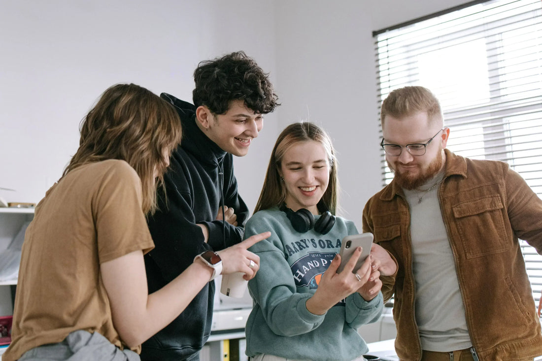 Four people looking at a smartphone together